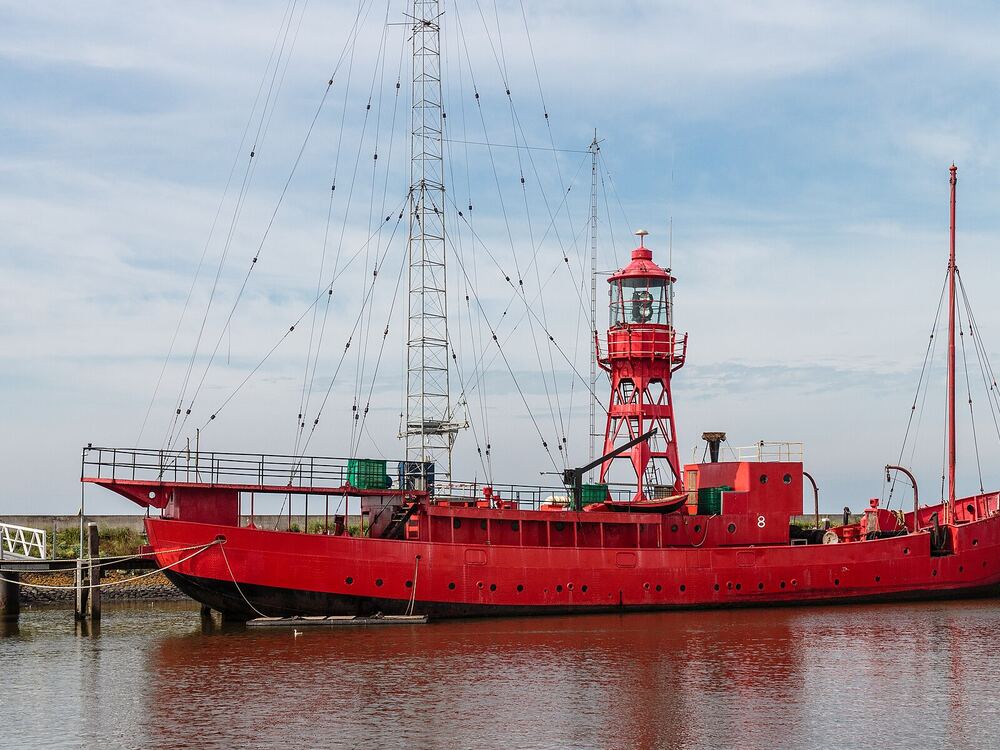 Het rode lichtschip Jenni Baynton afgemeerd in de haven van Harlingen, met de rode lichttoren op het dek